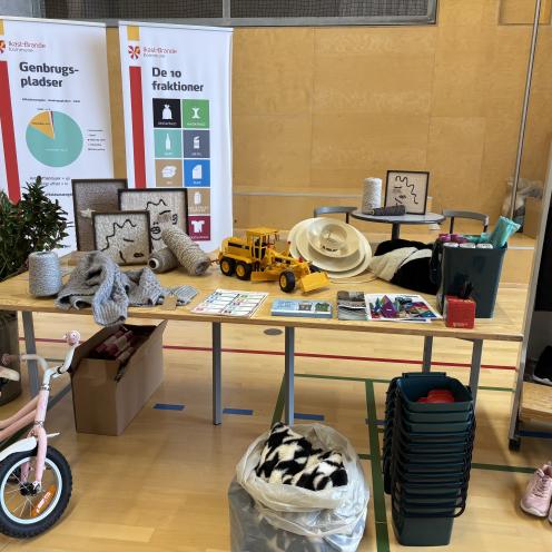 Billedet viser forskellige ting  sorteret op i bunker som de skal sorteres på genbrug